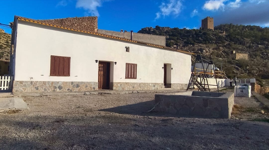 Exterior de la casa con la atalaya al fondo